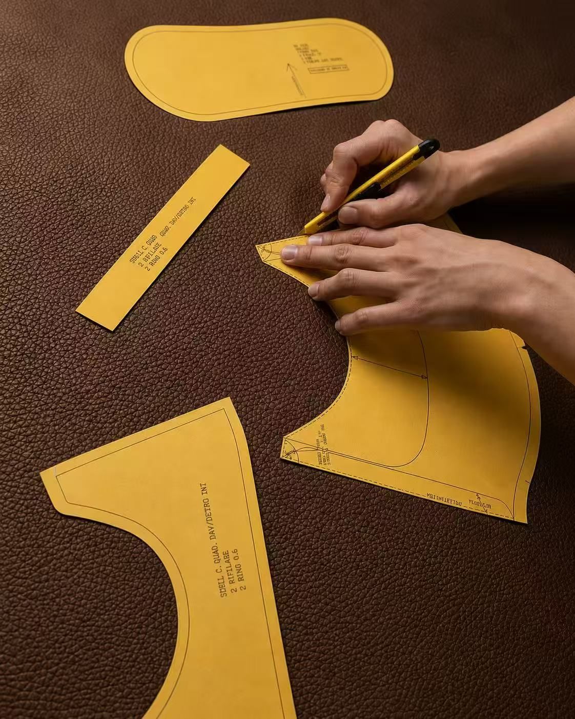 Leather craftsperson cutting pieces in the Florence atelier